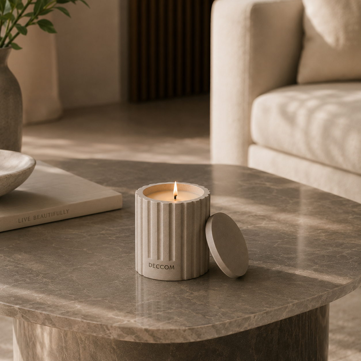 DECCOM Column Vessel soy candle styled on a marble coffee table in a warm minimalist interior